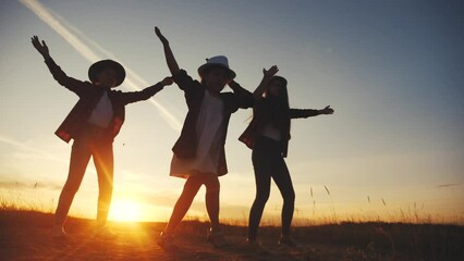 group of kids dancing in the park silhouette at lifestyle sunset. kid dream party concept. children dancing in nature at sunset. kids having fun at a picnic dream party