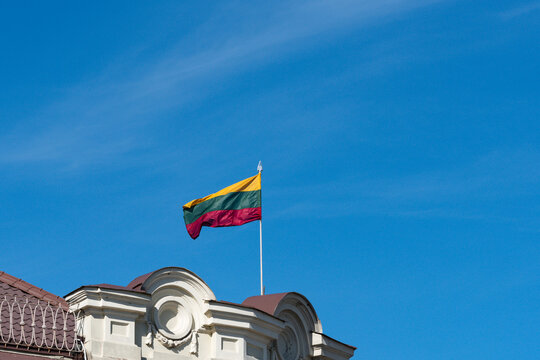 Lithuanian flag on top of a building against blue sky