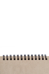 Craft notepad on springs with pages in natural beige color on an isolated on white background. Space for text. Vertical.