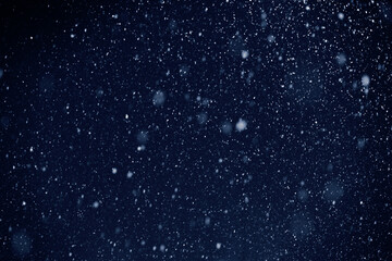 it's snowing, snowfall or snow storm against the dark sky, falling snowflakes natural background