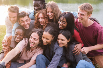 Group of young friends from different origins taking a selfie together outdoors in the park. Concept: diversity, pride, friendship