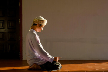 Religious muslim islam man in white session with prayer action to Allah in mosque on black background .concept for islamic pray, Ramadan, Eid al Fitr, eid ad-ha, meditation