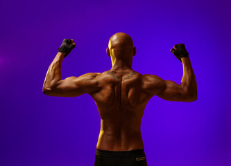 Fototapeta na wymiar Back view of naked torso of muscular man on studio background. Strength and motivation