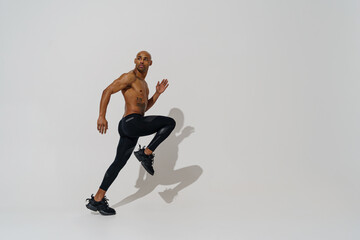 Fototapeta na wymiar Professional male athlete running isolated on white studio background with shadows