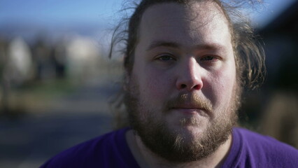 Fototapeta premium Portrait of a positive chubby young man close up face looking at camera. Casual male caucasian person with beard