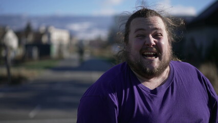 Fototapeta premium Person celebrating success feeling ecstatic standing outside. Happy emotion close up face. Tracking shot of One overweight joful male person. Triumph concept
