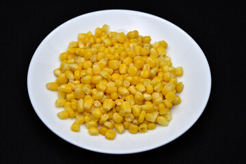 Fresh canned corn on a white plate. Corn salad. Yellow corn kernels.
