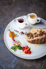 Dessert sponge cake with condensed milk and chocolate chips on a white plate