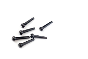 Pins for attaching acoustic guitar strings plastic black, filmed on a white background.