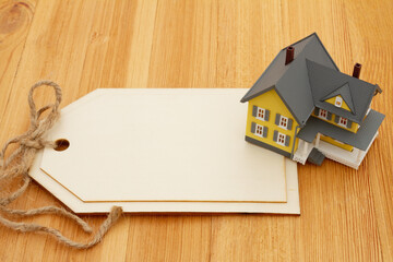Obraz na płótnie Canvas Blank gift tag with a house on a wood desk