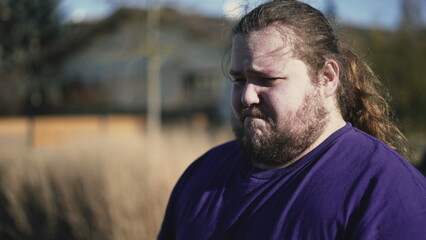 One angry young man feeling upset about past mistakes. Portrait of an overweight frustrated male person close up face in tracking shot