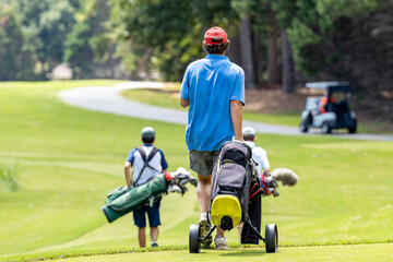 Teenage male golfers walking down the fairway