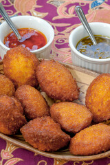 Brazilian food: acarajé with vatapá, sauce and pepper on a colorful table. Typical dish from Bahia, Brazil