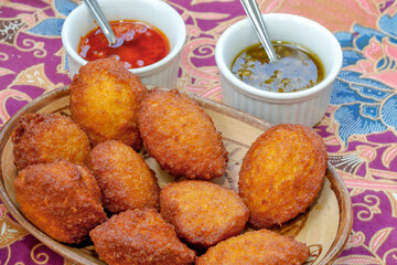 Brazilian food: acarajé with vatapá, sauce and pepper on a colorful table. Typical dish from Bahia, Brazil