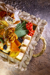 Assorted cheeses on a tray with nuts and honey