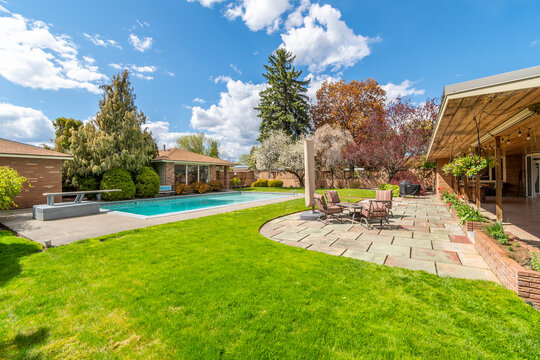 A Landscaped Back Yard With Deck, Patio, And Swimming Pool In A Mid-century Modern Home In The Pacific Northwest.