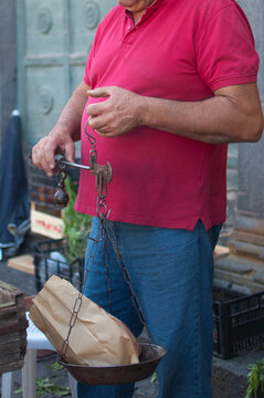 Unrecognizable Man Using A Traditional Weighing Scale In A Street Market