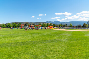 Families play at Pavilion Park during a summer festival and fair in the Spokane Washington suburb...