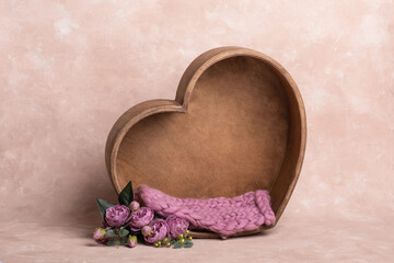 Obraz na płótnie Canvas background texture empty space for baby with wooden heart and mattress. basket for a newborn photo shoot. heart made of wood, decorated with beautiful roses