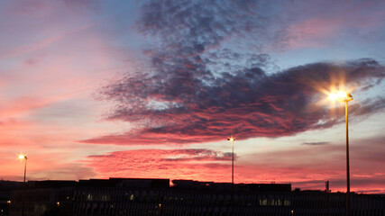 Sunset sky with colored clouds and street lamps.