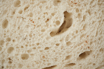 Natural background from a piece of white wheat bread. Close-up. Space for lettering and design.