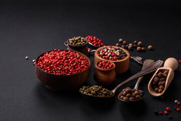 Composition, concept, consisting of several types of different colors of allspice in bowls and spoons
