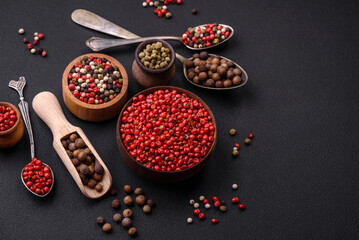 Composition, concept, consisting of several types of different colors of allspice in bowls and spoons
