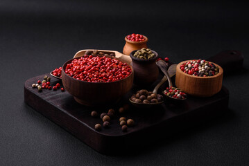 Composition, concept, consisting of several types of different colors of allspice in bowls and spoons