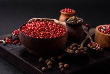 Composition, concept, consisting of several types of different colors of allspice in bowls and spoons