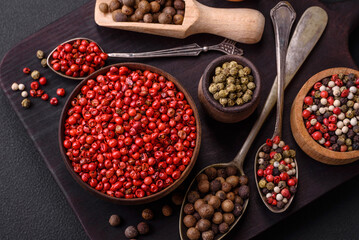 Composition, concept, consisting of several types of different colors of allspice in bowls and spoons