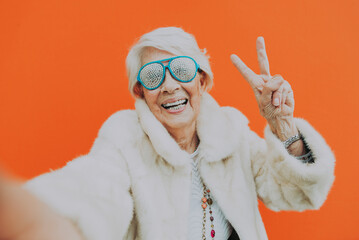 Funny grandmother dancing on colored background