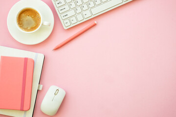 Office workspace. Woman flat lay pink office desk with keyboard, notebook and coffee cup..