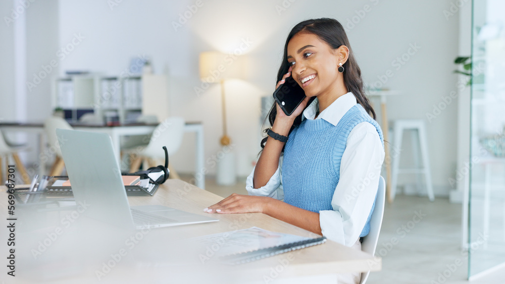 Wall mural Young businesswoman talking on her phone to a client in an office. Trendy marketing professional on scheduled time, using the online app for networking. Entrepreneur staying connected in a workplace