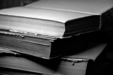 a stack of old books in monochrome photography
