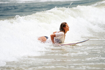 portrait beautiful mid adult caucasian woman surfing the waves in Brazil