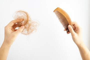 Hair loss problem, postpartum period, menstrual or endocrine disorders, hormonal imbalance, stress concept. Many hairs fall off after brushing. Female detangles hair with a comb, copy space