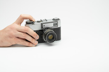 Hand pressing the shoot button on a vintage film camera isolated on white backgorund. Hand taking picture with an old film camera. Finger pressing the shoot button on a film camera 