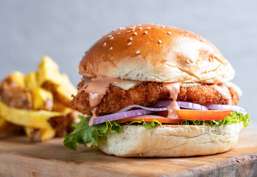 Delicious Fried Chicken Crispy Sandwich With Spicy Buffalo Sauce, Served With French Fries.