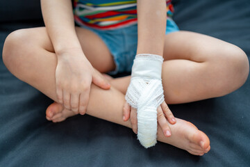 Little girl with broken finger on sofa at home on sick leave