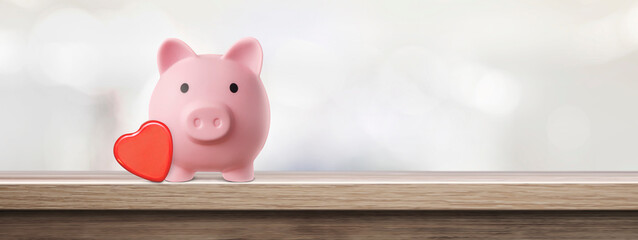 pink piggy bank with heart on an empty table - concept of protection and preservation of love - copy space
