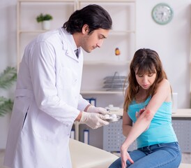 Young arm injured woman visiting young doctor traumatologist