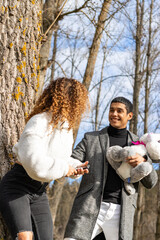 Boyfriend giving a teddy bear to girlfriend outdoors. Young latin man giving teddy bear to girlfriend on special day