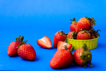 Fresas maduras y frescas en fondo azul.