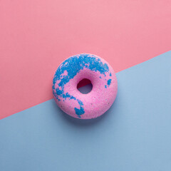 Round blue pink donut, on a blue pink background. Flat lay