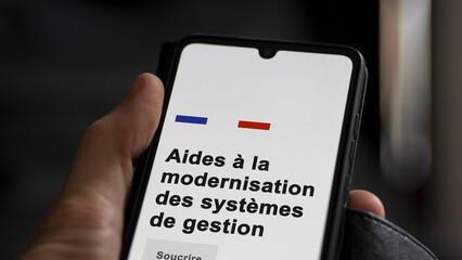 An entrepreneur subscribing to an aid on a screen. Translation of French text : aid to the modernization of management systems. Text in French.