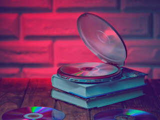 CD (MP3), discs and books on the table in retrowave style