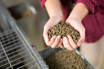 Worker showing feed for animal in her hands