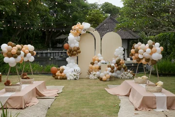 Muurstickers Creative gender neutral baby shower or birthday decoration in the garden. Bohemian style outdoor event set up with balloons. White cream peach caramel balloon arch kit. © triocean