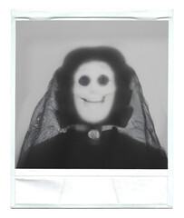 Instant picture print photograph of a victorian lady doll (a scary ghost with an ominous smile), isolated.
