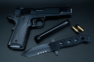 Weapon.  Model M1911 pistol and folding tactical knife.